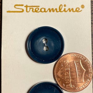 May include: Two navy blue buttons with a penny for size comparison, displayed on a vintage Streamline card. The card has the text "Streamline" in gold script and the price "70¢".