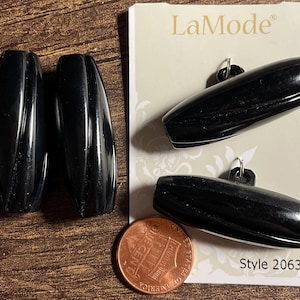 May include: Set of four black, oval-shaped LaMode buttons with a glossy finish. Two buttons are attached to a card with the LaMode logo and style number 20631. A penny is included for size reference.