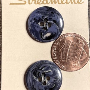 May include: Two blue and white swirl buttons on a vintage card. The card has the word "Streamline" in gold lettering and the price "90¢". A penny is next to the buttons for size comparison.