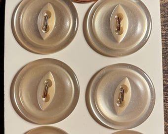 May include: Six oval, pale beige buttons with a central eyelet and a copper-coloured metal shank. A US penny and text reading "2006" and "40¢" are also visible. The buttons are on a white card with the text "SIZE 30-3/4".
