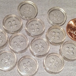 May include: Twelve clear plastic buttons with four holes each. The buttons are approximately the size of a US penny.