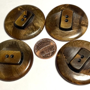 May include: Four brown and black plastic buttons with two holes each. The buttons have a marbled pattern and a raised rectangular design.