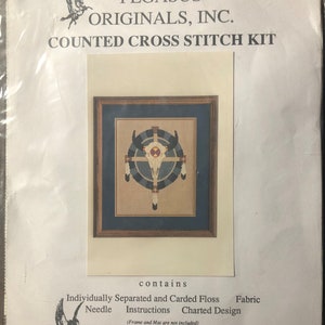 May include: A counted cross stitch kit featuring a Native American design with a buffalo skull and feathers. The kit includes individually separated and carded floss, a needle, instructions, and a charted design. The kit is from Pegasus Originals, Inc. and is located at 129 Minnie Fallaw Road, Lexington, SC 29073.