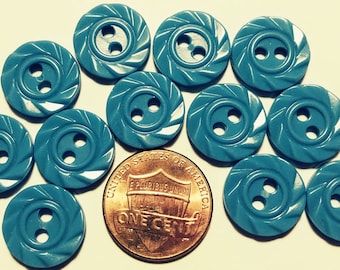 May include: Twelve turquoise plastic buttons with two holes each. The buttons have a swirl design and are approximately the size of a UK penny.