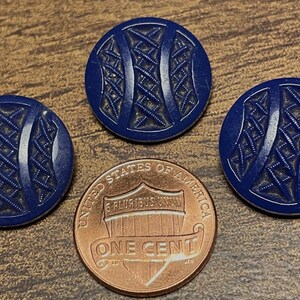 May include: Three blue plastic buttons with a geometric design. The buttons have a raised, woven pattern.