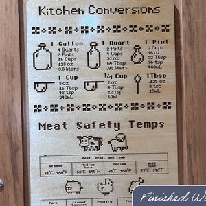 May include: Wooden kitchen conversion chart with measurements for volume and meat safety temperatures. Includes conversions for gallons, quarts, pints, cups, and tablespoons. Features pixelated illustrations and the text "Finished Wood".