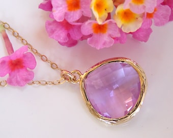 May include: A delicate gold chain necklace with a large, faceted, light purple gemstone pendant. The pendant is set in a gold bezel setting and has a slightly irregular shape.