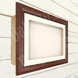May include: A rectangular picture frame with a dark brown wooden frame and a white mount. The frame is mounted on a light-coloured wooden surface. The frame is empty, ready for a photo or artwork.