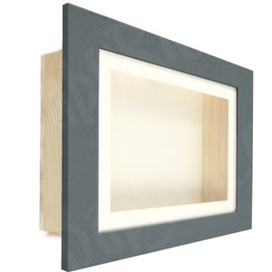 May include: A gray shadow box frame with a white mat and a wood backing. The frame is made of wood and has a smooth finish.