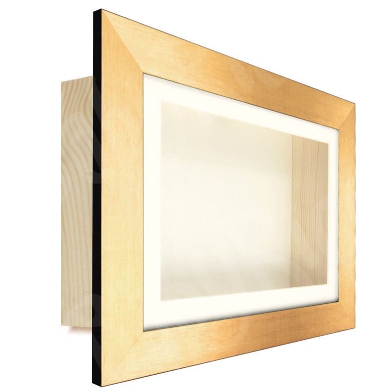 May include: A gold-colored wooden shadow box frame with a black inner edge. The frame is empty and ready to display a treasured item.