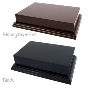 May include: Two rectangular display plinths, one mahogany-effect and one black. Both have a stepped base.