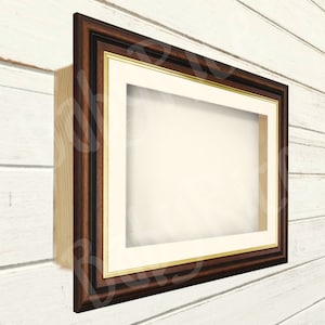 Könnte beinhalten: Ein dunkelbrauner Holzrahmen mit goldener Verzierung und einem weißen Passepartout. Der Rahmen ist auf einer weißen Holzplatte montiert.