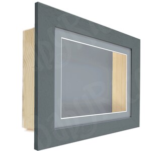 May include: A gray wood picture frame with a single mat and a small opening for a display item. The frame has a light wood backing.