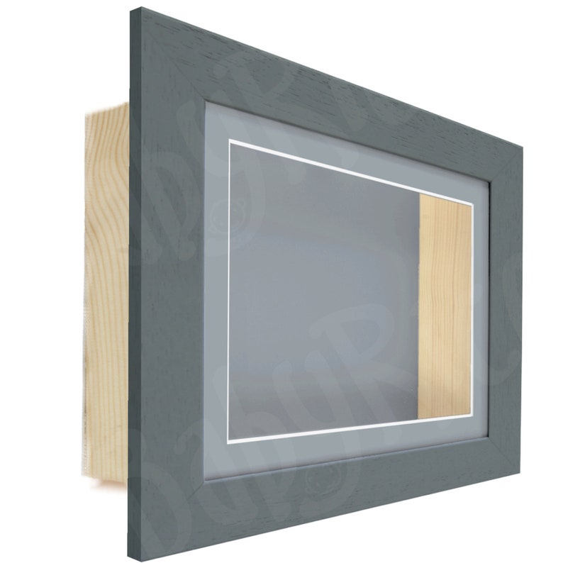 May include: A gray wood picture frame with a single mat and a small opening for a display item. The frame has a light wood backing.