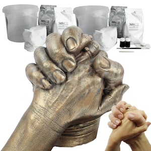 May include: A bronze-coloured hand casting kit with two hands clasped together. The kit includes four bags of casting powder, two bottles of paint, a brush, and a tool for smoothing the casting.