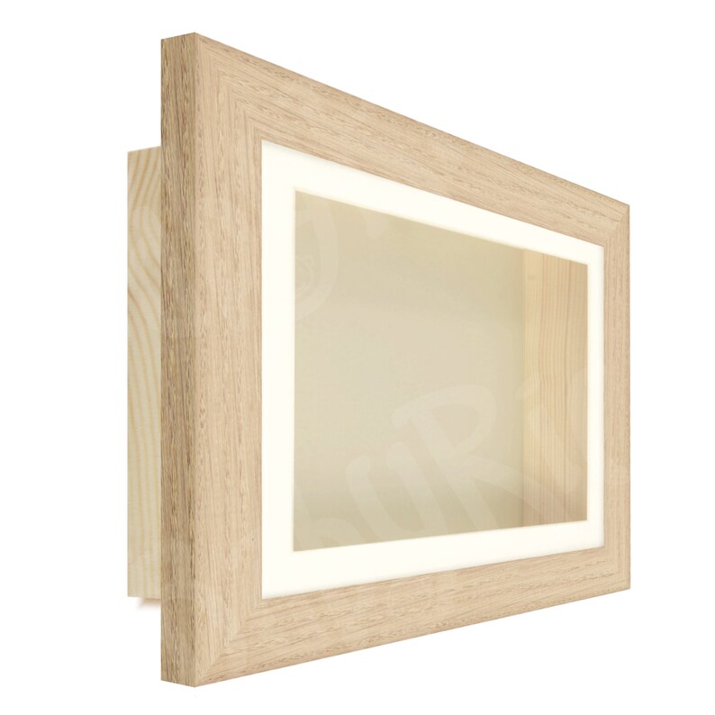 May include: A light wood shadow box frame with a white mat and a clear glass front. The frame is perfect for displaying small items, such as coins, jewelry, or other collectibles.