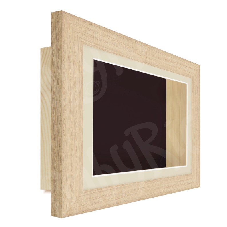 Puede incluir: Un marco de fotos de madera natural con un passe-partout blanco y una caja de sombra. El marco mide 30,5 x 40,6 cm.