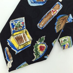 May include: Black silk tie with a repeating pattern of cigars, cigar boxes, and tobacco leaves. The tie features the text "Fine Cigars" and "Imported".