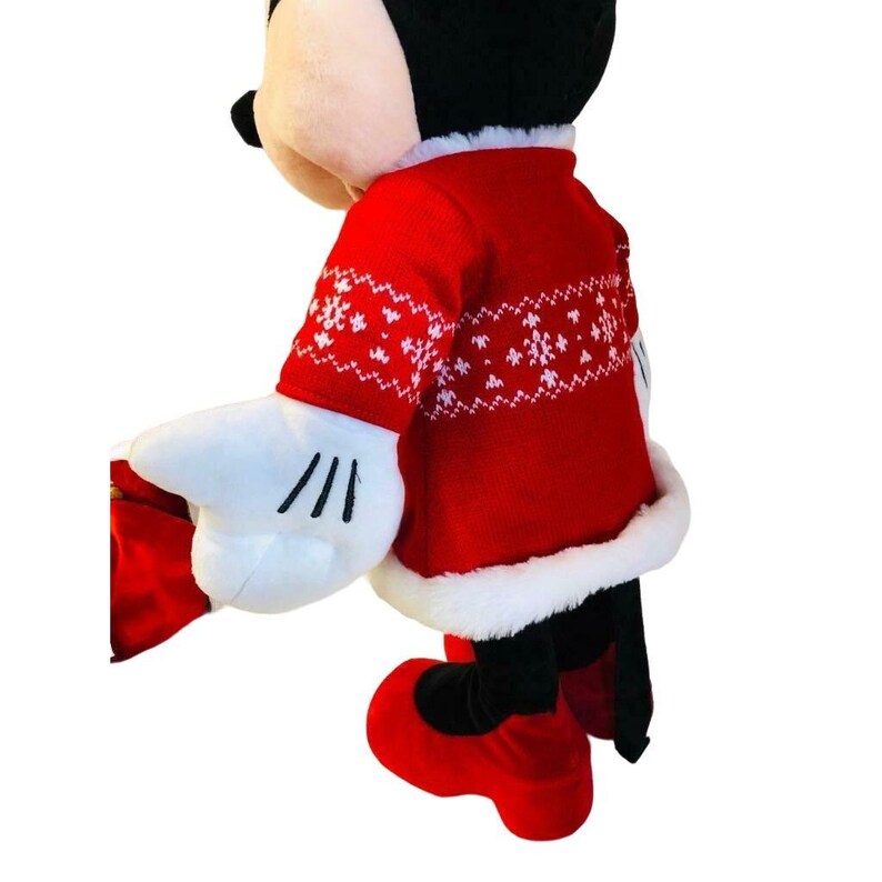 May include: A plush Mickey Mouse figure wearing a red sweater with white snowflake patterns. The sweater has white trim and is paired with red shoes and white gloves with black lines. The figure has black ears and a black tail.