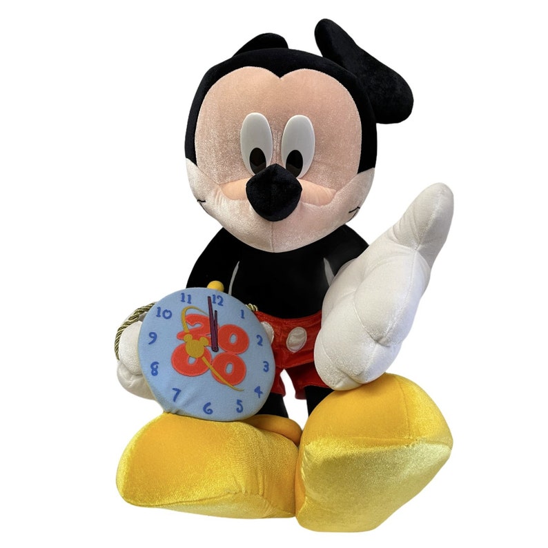 Puede incluir: Un peluche de Mickey Mouse en negro, rojo, blanco y amarillo. Mickey sostiene un reloj azul con el n&uacute;mero 88. La figura tiene zapatos amarillos grandes y guantes blancos.
