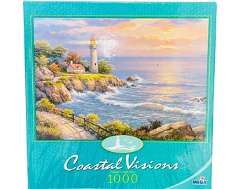 May include: A 1000-piece jigsaw puzzle featuring a coastal landscape with a lighthouse, ocean waves, and a sunset. The puzzle box has a teal border and the words "Coastal Visions" and "1000" printed on it.