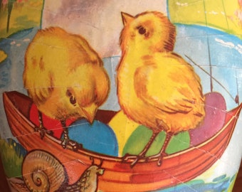 May include: A vintage Easter egg with a colorful illustration of two chicks in a boat with a snail on a log. The egg is decorated with blue, yellow, red, and green colors.