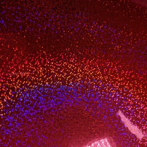 May include: Red iridescent fabric with a gradient of orange, blue, and purple glitter.