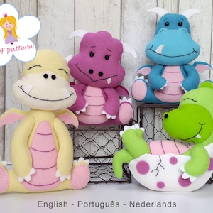 Puede incluir: Cuatro juguetes de dragón de fieltro. Un dragón amarillo con detalles rosas, un dragón morado con detalles rosas, un dragón azul con detalles rosas y un dragón verde en un huevo con lunares rosas.