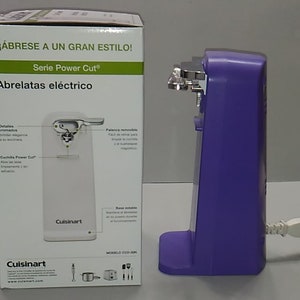 Puede incluir: Un abrelatas el&eacute;ctrico blanco con base morada y mango cromado. La caja muestra el producto en uso y presenta el texto "&iexcl;&Aacute;BRESE A UN GRAN ESTILO! Serie Power Cut&reg; Abrelatas el&eacute;ctrico".