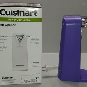 Puede incluir: Abrelatas el&eacute;ctrico morado con base blanca y detalles cromados. La caja muestra las caracter&iacute;sticas del producto y el logotipo de Cuisinart. El producto se llama "Power Cut Series Can Opener".