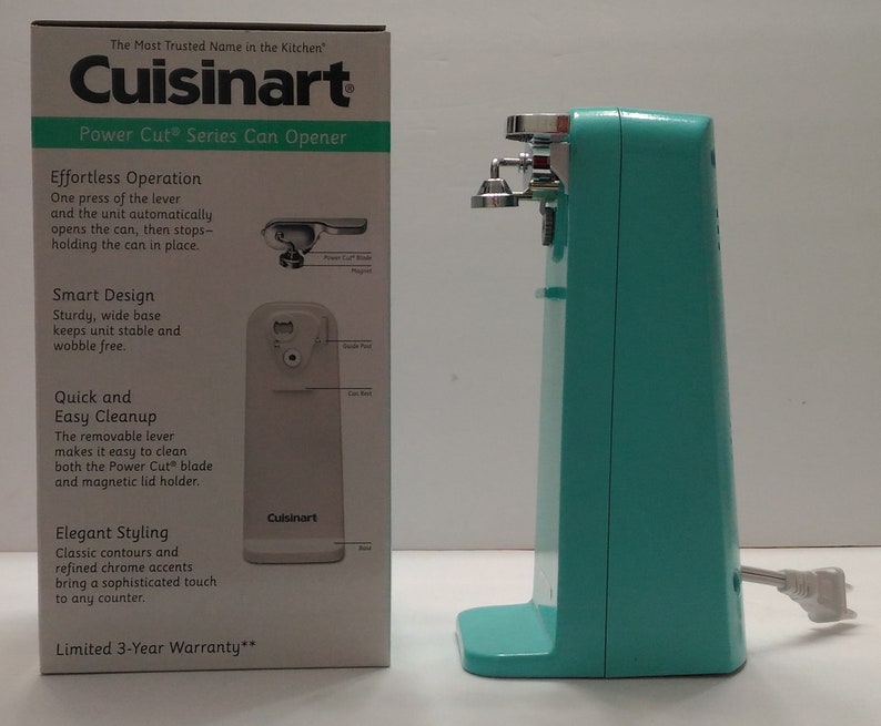 Pode incluir: Um abridor de latas el&eacute;trico turquesa com uma alavanca prateada e uma base branca. A caixa mostra a marca Cuisinart e as caracter&iacute;sticas do abridor de latas. O texto na caixa diz "The Most Trusted Name in the Kitchen" e "Power Cut Series Can Opener".