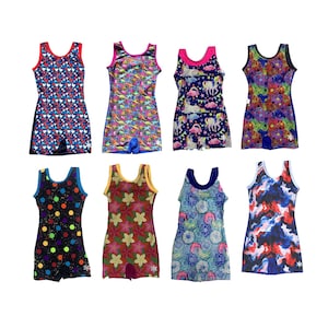 May include: Eight colorful leotards with various patterns, including hearts, dinosaurs, unicorns, and floral designs. The leotards are sleeveless with a scoop neck and shorts-style bottoms. The color palette includes red, blue, green, and pink.