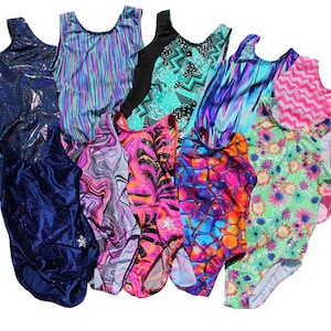 May include: A collection of colorful gymnastics leotards. The leotards feature various patterns, including swirls, stripes, and floral designs. Colors include blue, pink, green, and purple. Some leotards have a shiny, metallic finish.