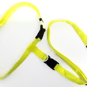 May include: A bright yellow dog harness and leash set. The harness features black plastic buckles and a white metal ring. The leash has a metal clasp for easy attachment. The set is designed for pet owners.