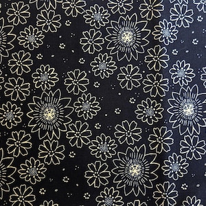 Op de afbeelding: Donkerblauwe stof met een herhalend patroon van witte madeliefachtige bloemen. De bloemen hebben gedetailleerde centra en zijn verspreid over het oppervlak. Kleine witte stippen vullen de ruimtes tussen de bloemen en creëren een bloemenpatroon.