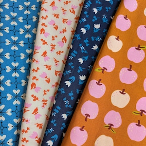 Peut inclure: Quatre échantillons de tissu avec différents motifs. L'un est bleu avec des motifs blancs en forme de cœur, un autre est blanc cassé avec des motifs floraux roses et oranges, un troisième est bleu marine avec des motifs floraux blancs et bleus, et le dernier est marron avec des motifs de pommes roses.