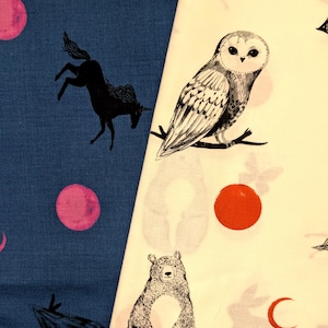 May include: Two pieces of fabric featuring distinct patterns. The left side is dark blue with black silhouettes of unicorns and pink circular shapes. The right side is cream-coloured with a black owl illustration, a bear, and orange circles.