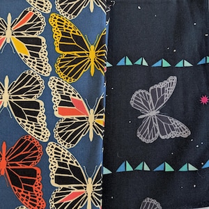 Puede incluir: Dos muestras de tela con estampados de mariposas. Una muestra presenta grandes mariposas en amarillo, rojo, negro y blanco sobre un fondo azul. La otra tiene una mariposa gris, triángulos y estrellas sobre un fondo azul oscuro.