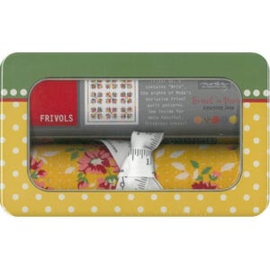 Puede incluir: Una lata amarilla y verde con lunares y una ventana transparente, que contiene rollos de tela y una cinta métrica. La tela es amarilla con un estampado floral. La lata dice "Frivols" y "Bread n' Buis American Jane".