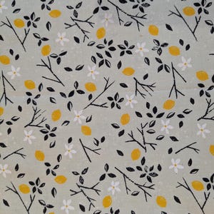 Może przedstawiać: Jasnozielony materiał z powtarzającym się wzorem czarnych gałęzi, białych kwiatów i żółtych cytryn.