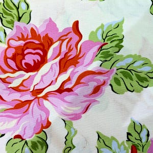 May include: A fabric print featuring a large, stylized rose in shades of pink, red, and white. The flower is surrounded by vibrant green leaves with light blue accents, all set against a pale, off-white background with a subtle, mottled texture.