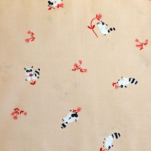 Puede incluir: Una tela de color melocotón claro con un patrón repetido de mapaches de dibujos animados y flores rosas. Los mapaches son negros y blancos con detalles en rojo, y las flores tienen tallos y pétalos rojos. El diseño es caprichoso y juguetón.