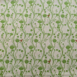 Puede incluir: Una tela blanca con un patrón repetido de enredaderas verdes con hojas y pequeños pájaros rojos. Las enredaderas tienen hojas en forma de corazón y los pájaros están estilizados.