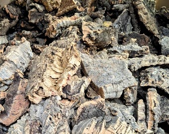 May include: A close-up of a pile of natural cork bark pieces. The cork bark is a light brown color and has a rough, textured surface.