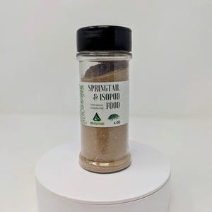 May include: A clear glass jar with a black lid filled with brown springtail and isopod food. The label reads "Springtail & Isopod Food 100% Natural Complete Diet" with a small green logo that says "ecobotanicals" and a picture of a small isopod. The jar is 4 oz.