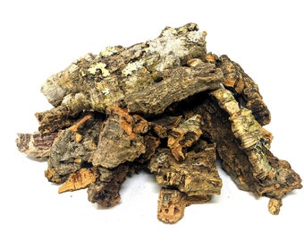 May include: A pile of brown and gray cork bark pieces, some with a light green lichen growth, on a white background.