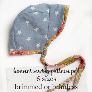 May include: A blue bonnet sewing pattern with white stars printed on the fabric. The bonnet is trimmed with a floral fabric. The text on the image reads "bonnet sewing pattern pdf 6 sizes brimmed or brimless".