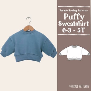 May include: A blue puffy sweatshirt sewing pattern for children sizes 0-3 to 5T. The pattern is from Parade Sewing Patterns.