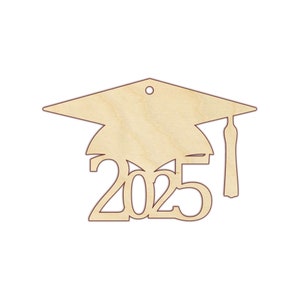 Puede incluir: Adorno de gorro de graduaci&oacute;n de madera con el a&ntilde;o 2025 recortado. El adorno es de color marr&oacute;n claro.