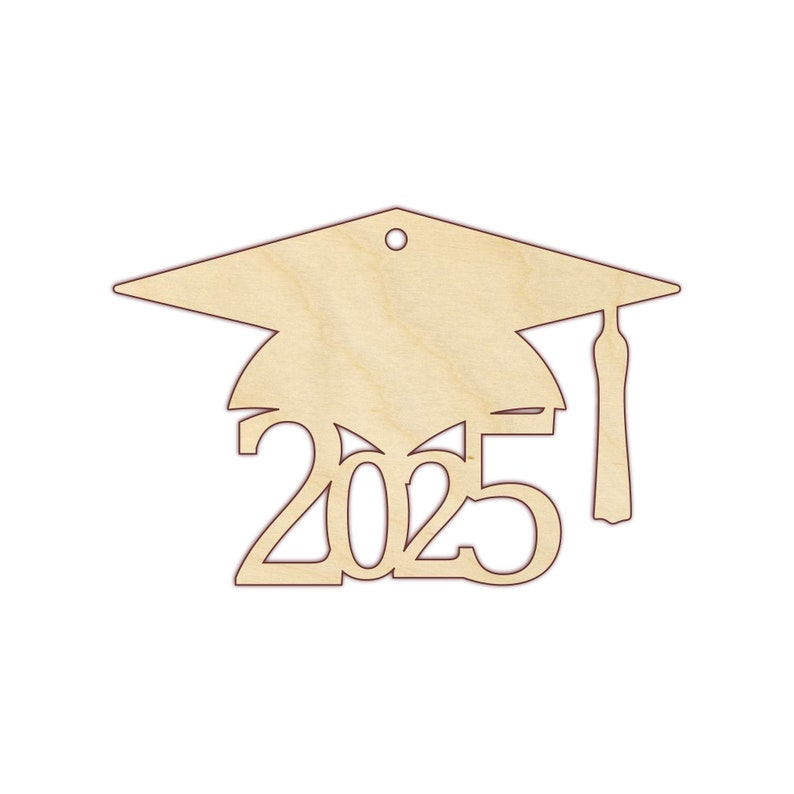 Puede incluir: Adorno de gorro de graduaci&oacute;n de madera con el a&ntilde;o 2025 recortado. El adorno es de color marr&oacute;n claro.